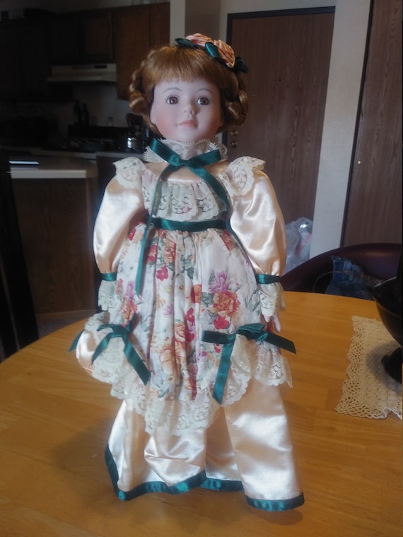 Porcelain Doll # 205 golden yellow dress with bag. Circa. 1980s with stand