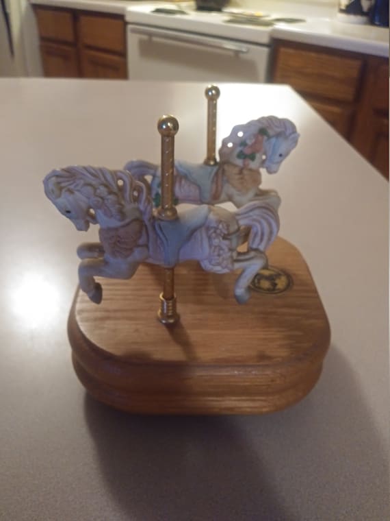 2 carousel collection porcelain horses on brass poles connected to a wooden music box Circa. 1999
