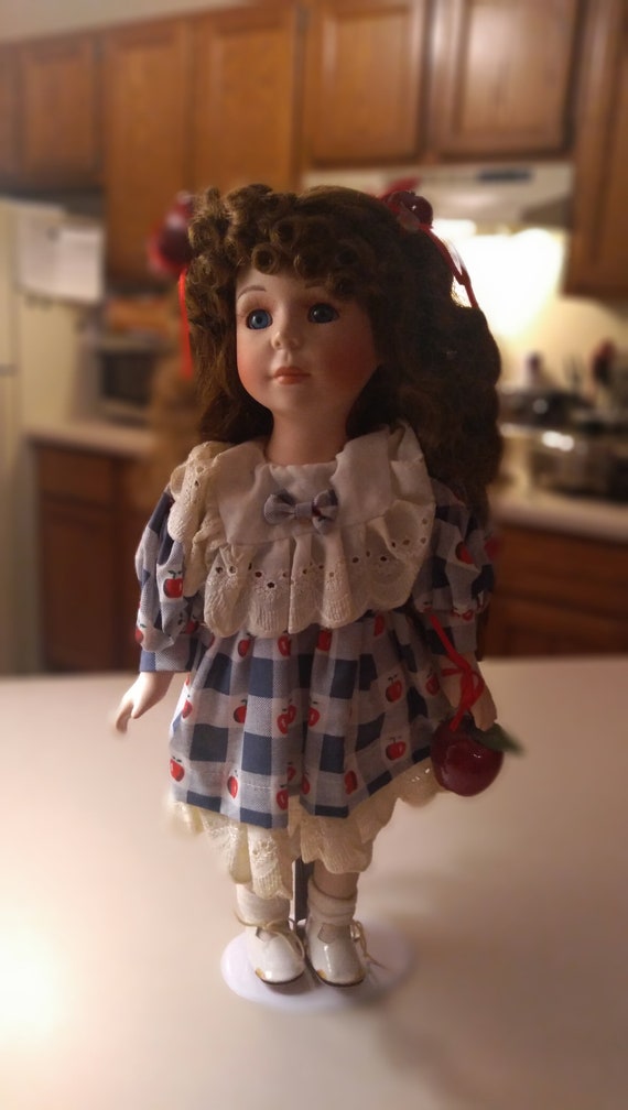Porcelain doll # 13 Apple theme doll from the 1980s. With stand included.