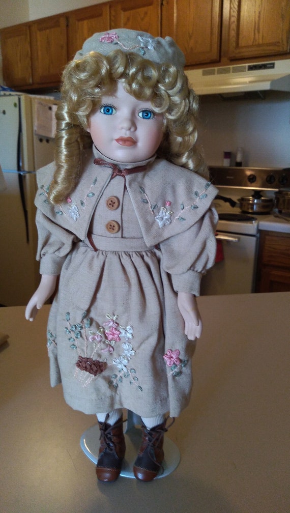 Porcelain doll #28 khaki dress with flower embroidery. Circa. 1980s.