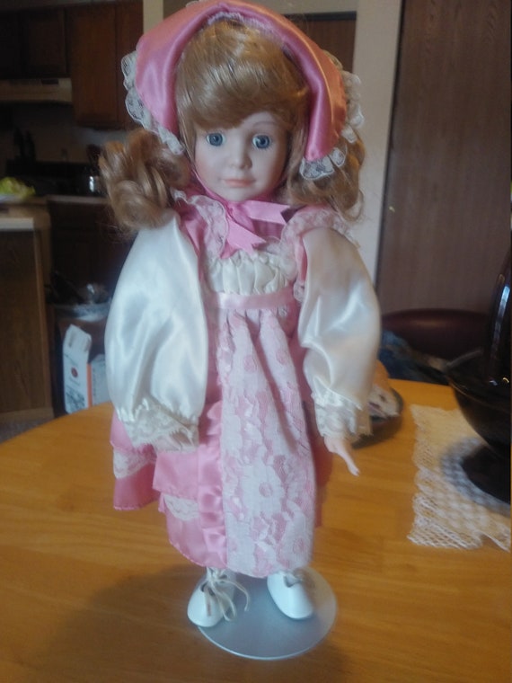 Porcelain Doll # 2008 with pink satin dress and white lace. Circa. 1980s with stand.