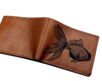 May include: A brown leather wallet with a black engraved image of a goldfish.