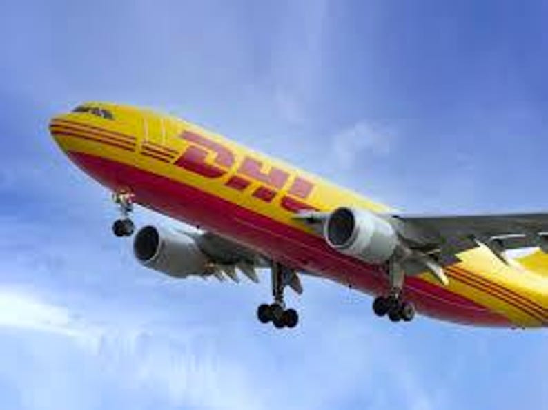 May include: A yellow and red DHL cargo airplane in flight against a blue sky. The plane has two engines and the DHL logo is prominently displayed on the side of the fuselage.