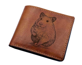 May include: A brown leather wallet with a stitched edge and a laser engraved image of a hamster.