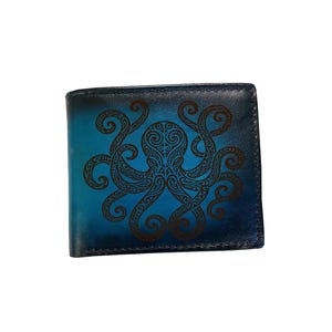 May include: A bi-fold wallet featuring a gradient blue and black finish with a dark brown octopus illustration centred on the front. The octopus design is composed of intricate swirling patterns and lines covering its head and eight tentacles.