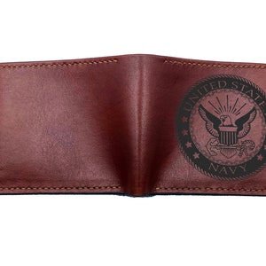 May include: Brown leather wallet with a United States Navy emblem embossed on the front.