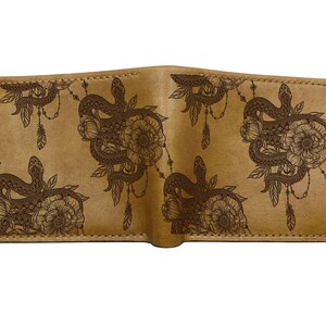Peut inclure: Un portefeuille bifold beige avec un motif répétitif gravé au laser en brun foncé représentant des serpents enroulés, des fleurs épanouies et des plumes suspendues. Le portefeuille présente des coutures visibles sur les bords et une finition mate.