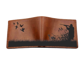 May include: A brown leather wallet with a silhouette of a hunter and ducks in flight. The design is on both the front and back of the wallet.