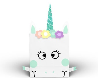 Può includere: Una borsa regalo bianca a forma di unicorno con un corno turchese, fiori rosa, gialli e viola e un nastro turchese. La borsa ha un viso carino con occhi neri e ciglia.