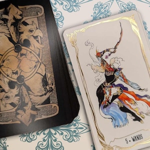 May include: A tarot card with a gold border and a white background. The card depicts a person in a black and white outfit holding a staff. The card is labeled "5 - Wands".