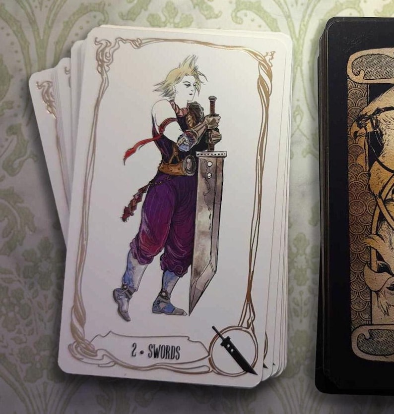 May include: A white card with gold trim features a drawing of a character holding a sword. The card is labeled "2 - Swords".