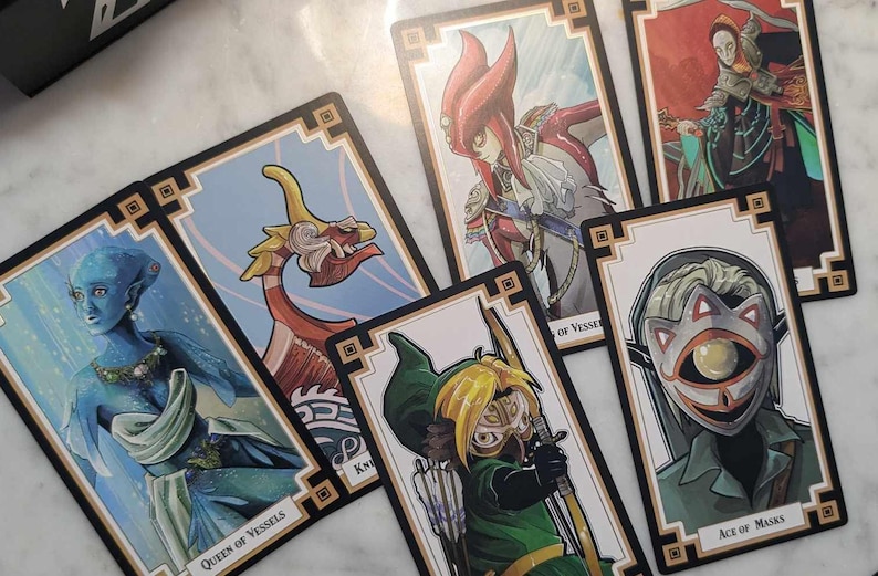 May include: A set of playing cards featuring illustrations of characters from the Legend of Zelda video game series. The cards are decorated with a gold and black border and feature a variety of characters, including Link, Zelda, and Ganondorf. The cards are in a variety of colors, including blue, green, red, and yellow.