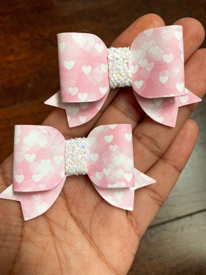 Adorable pink and white watercolour heart faux leather and chunky glitter bows pink and white heart Valentine\u2019s pigtail bows or headbands.