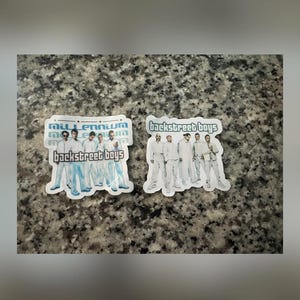 May include: Two stickers featuring the boy band Backstreet Boys. One sticker has the text "Millennium" above "Backstreet Boys" with a group photo. The other sticker has the band's name with a group photo. Both stickers have a white border.
