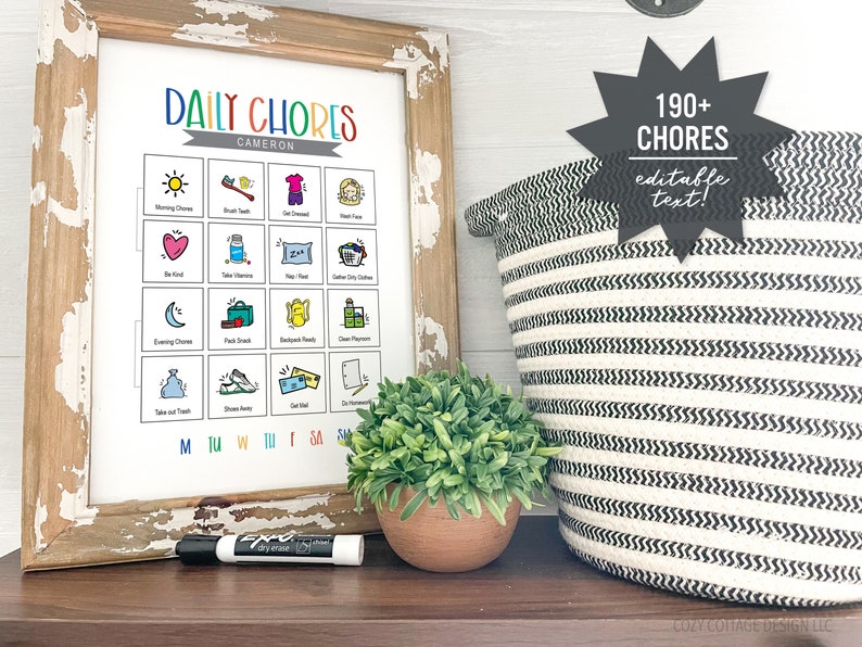 May include: A printable chore chart with colorful illustrations and the text "DAILY CHORES" and "CAMERON". The chart is framed in a rustic wooden frame and is sitting on a wooden surface. A black dry-erase marker is next to the chart. A black and white striped basket is in the background.