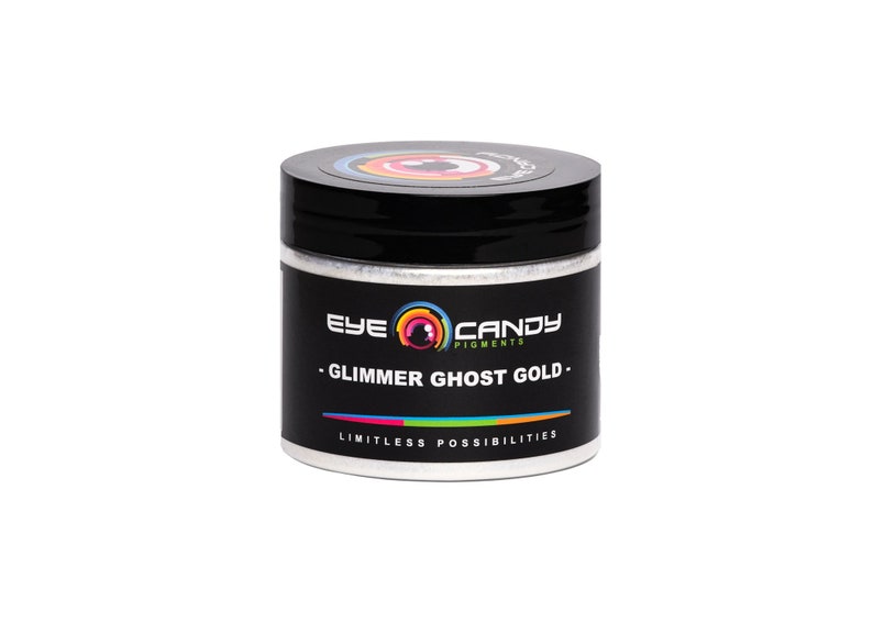 May include: A white jar with a black lid and a label that says "Eye Candy Pigments - Glimmer Ghost Gold - Limitless Possibilities".