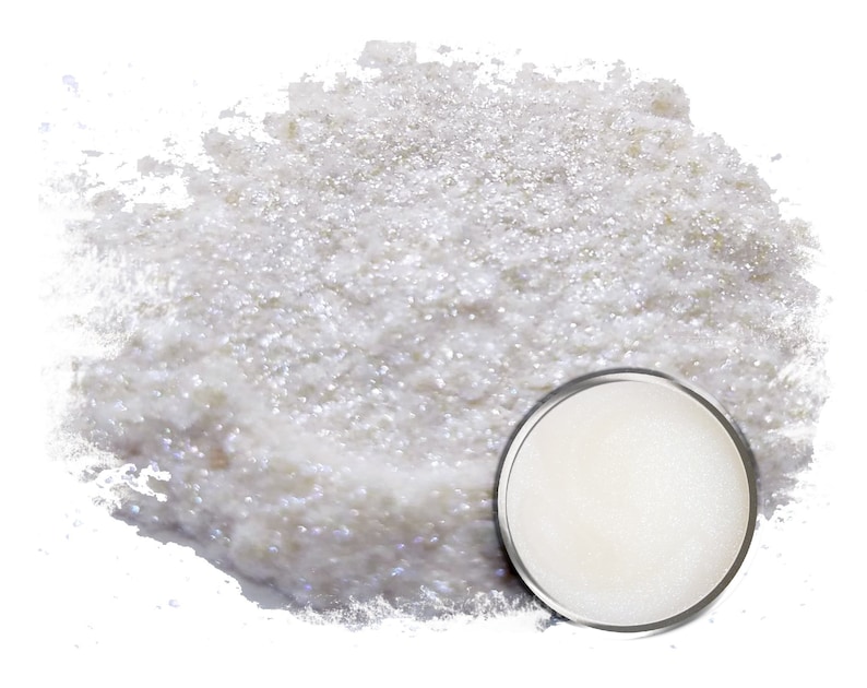 May include: A white iridescent glitter powder in a small round container. The powder is loose and has a shimmery finish.