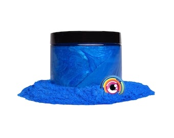 May include: A jar of blue iridescent mica powder with a black lid. The powder is spread out on a white surface.