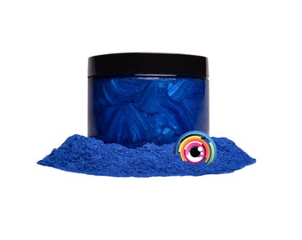 May include: A jar of blue mica powder with a black lid. The powder is a deep blue color with a slight shimmer. The jar is sitting on a pile of the same blue mica powder.