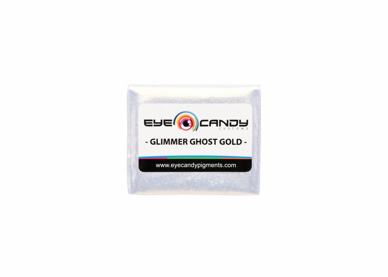 May include: A small white packet of glimmer ghost gold pigment from Eye Candy Customz. The packet has a black label with the company logo and the text "Glimmer Ghost Gold" and "www.eyecandy pigments.com".