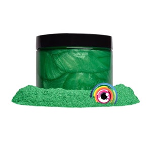 May include: A jar of green mica powder with a black lid. The powder is a shimmery green color and is surrounded by a pile of the same powder.