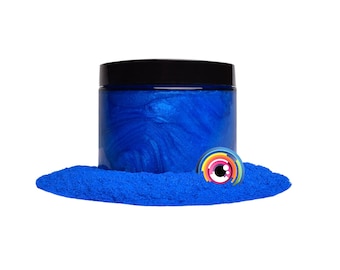 May include: A jar of bright blue iridescent mica powder. The powder is in a clear jar with a black lid. The powder is surrounded by a small pile of the same powder.