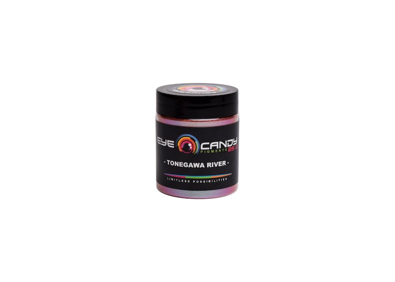 May include: A jar of Eye Candy Pigments in a pearlescent pink hue, with a black lid. The label features the text "EYE CANDY PIGMENTS" and "-TONEGAWA RIVER-". The jar is set against a white background.