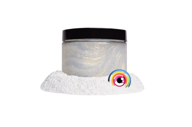 May include: A white jar with a black lid filled with iridescent glitter. The jar is sitting on a pile of white glitter.