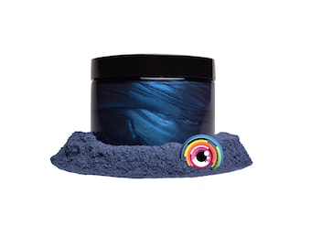 May include: A jar of dark blue metallic pigment powder. The powder is in a small pile in front of the jar. The jar has a black lid.