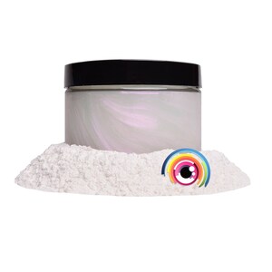 May include: A white iridescent powder in a black jar with a rainbow eye sticker on top of the powder.