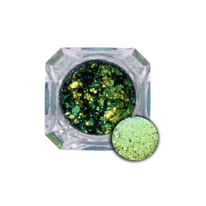 May include: A small jar of green and gold iridescent glitter flakes. The glitter is in a clear square jar with a lid. There is a small pile of glitter next to the jar.