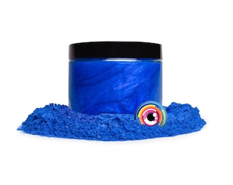 May include: A jar of bright blue iridescent mica powder. The powder is in a small pile in front of the jar.