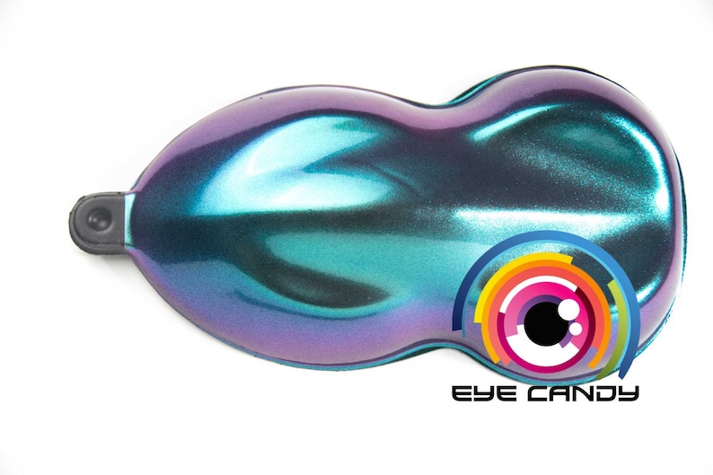 May include: A pearlescent, iridescent paint sample in shades of teal, purple, and blue. The product has a smooth, glossy finish and a unique color-shifting effect. The logo "EYE CANDY" is visible.