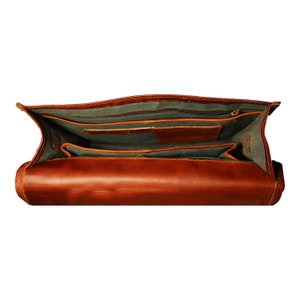 Interior view of a practical leather backpack, featuring a spacious organized storage. This versatile bag is designed to keep your travel essentials neatly arranged and easily accessible. Featuring zippered pocket.