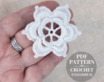 May include: White crochet flower motif with a six-pointed star in the center. PDF pattern for crocheting the flower is included.  Crochet pattern in English (US).