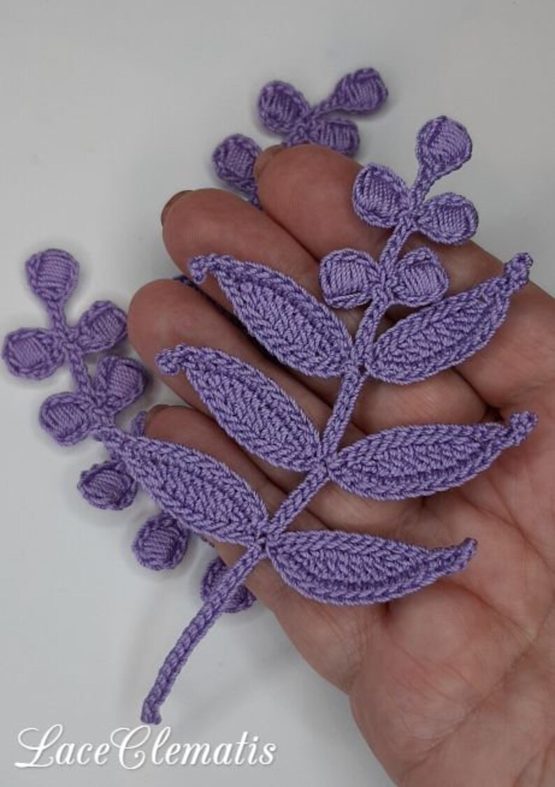May include: A set of three purple crocheted flower embellishments. The embellishments are in the shape of leaves and flowers. The embellishments are perfect for adding a touch of handmade charm to any project.