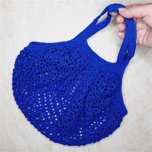 May include: A blue crocheted tote bag with a wide, open top and two handles. The bag is made of a fine, delicate yarn and has a lacy, openwork design.