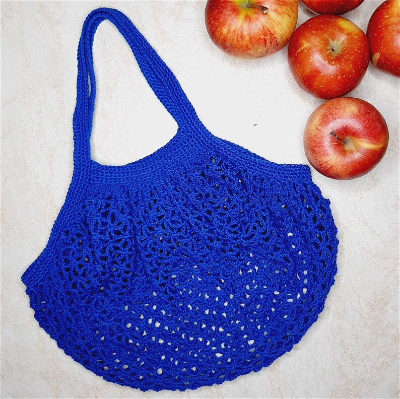 May include: A blue crocheted mesh bag with a wide, open top and a single handle. The bag is made of a fine, delicate yarn and has a loose, airy texture.