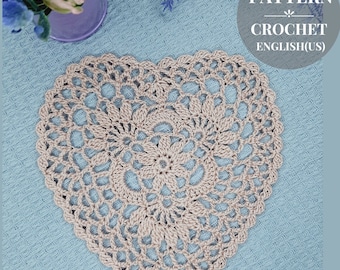 May include: A crochet heart doily in a beige color on a light blue background. The doily has a delicate lace pattern and is perfect for adding a touch of handmade charm to your home decor.