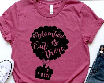 May include: A maroon t-shirt with a black graphic of a house flying in a hot air balloon with the text "Adventure is out there".
