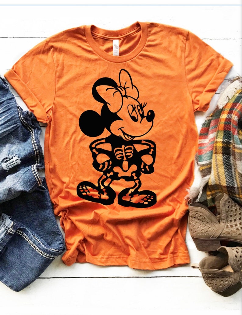 May include: Orange t-shirt with a black skeleton Minnie Mouse graphic. The shirt is made of a soft, comfortable material.