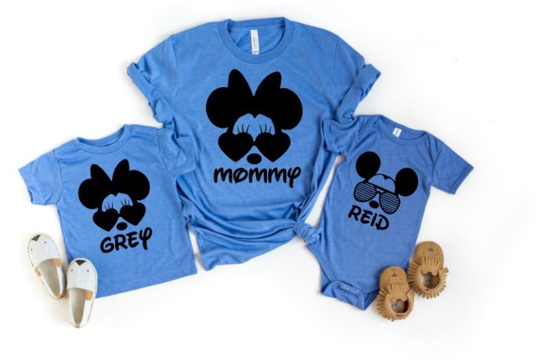 May include: Three blue t-shirts with black Mickey Mouse and Minnie Mouse character designs. The shirts say "mommy", "Grey", and "Reid".