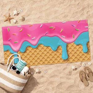 May include: A beach towel with a colorful ice cream design. The towel features a waffle cone base topped with pink frosting, blue drips, and colorful sprinkles. A beach bag, sunglasses, and sandals are in the sand.