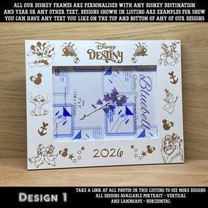 May include: White Disney-themed photo frame with etched Disney character designs and the word "Destiny". The frame includes the year "2026" and is sized for a 7" x 5" (178 x 127mm) photo. The frame has a horizontal orientation.