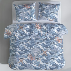 May include: A blue and white comforter set with a sea-themed pattern. The bedding features a repeating design of seashells, starfish, and coral against a wavy background. The set includes a comforter and two matching pillowcases.