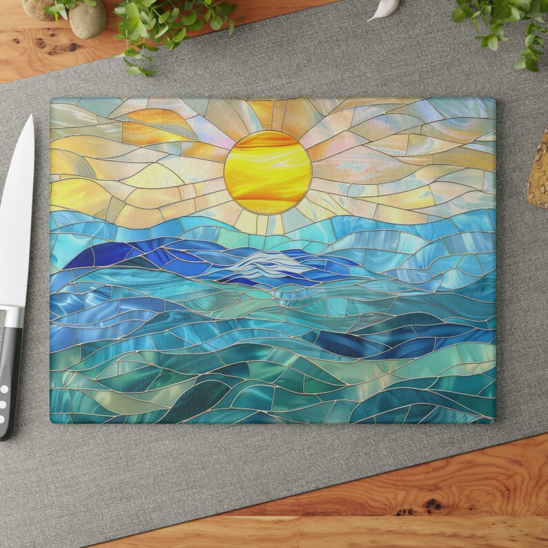 A stained glass style cutting board with a blue and green ocean scene and a yellow sun in the sky.