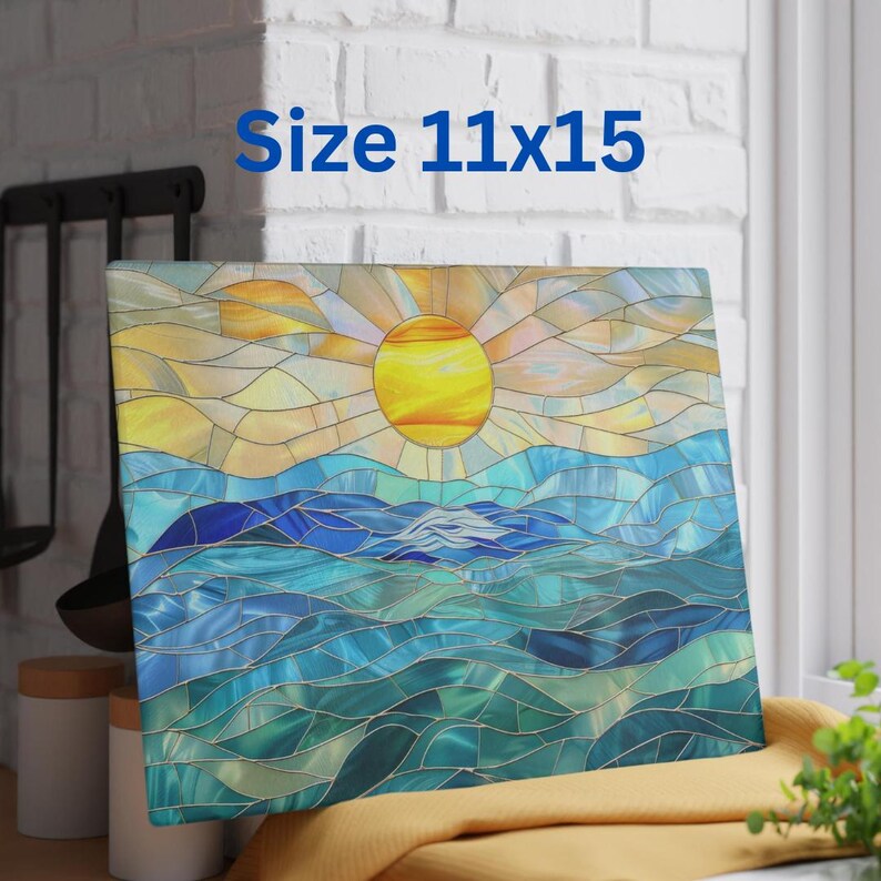May include: A stained glass style cutting board with a blue and green ocean scene and a yellow sun in the sky. The board is 11x15 inches.