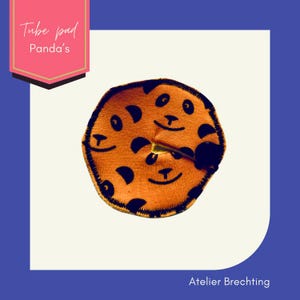 May include: Orange tube pad with a panda face design. The pad is made of soft fabric and has a black outline. The text "Tube pad Panda's" is written on a pink label.