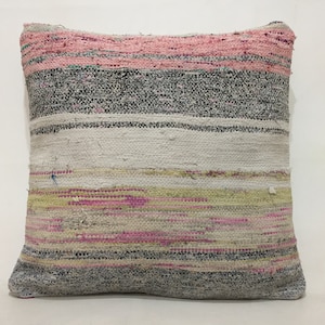 May include: Square cushion with a woven, striped pattern. The design includes horizontal bands of pink, grey, white, and yellow-green. The cushion is made of a textured fabric, suitable for home decor.