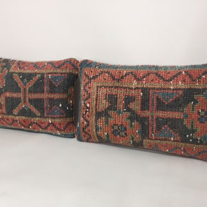May include: Two rectangular throw pillows with a traditional Turkish kilim pattern in shades of red, blue, green, and black.